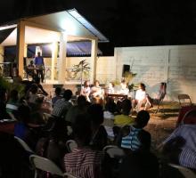 A public reading held at night in the court yard of a community art center.jpg