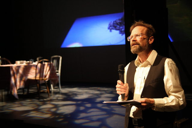 Christopher Merrill holding a microphone