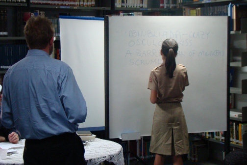 Chris Merrill watches as someone writes onto a whiteboard.