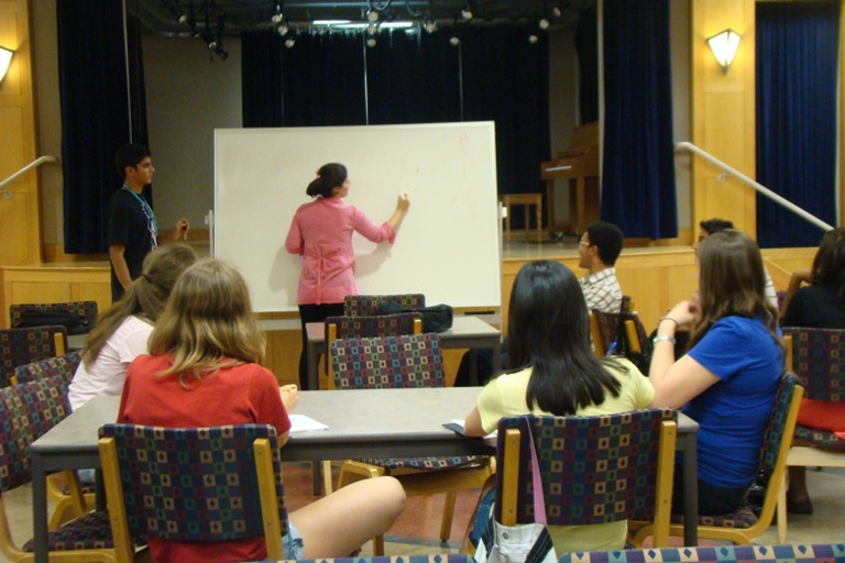 Between the Lines participants sit at a table while getting an Arabic lesson.