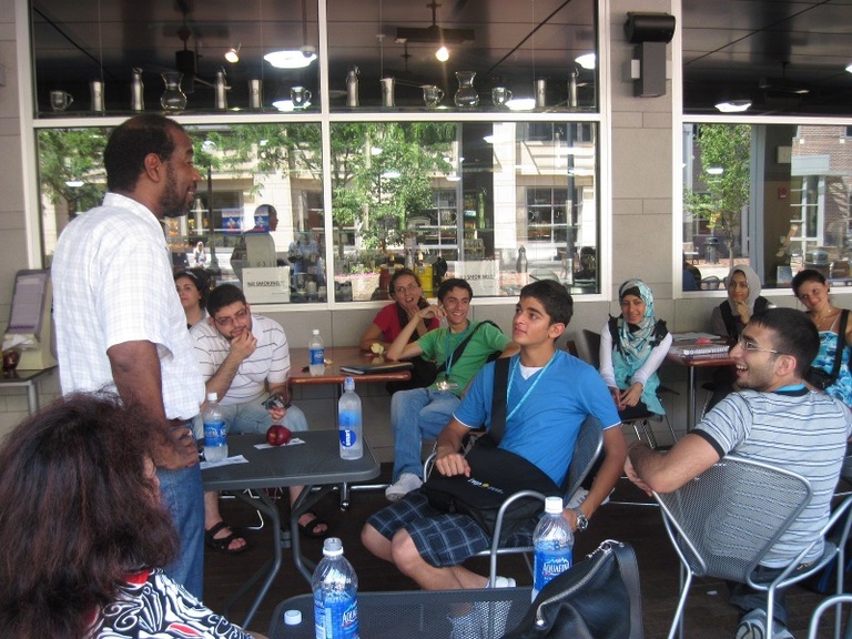 Instructor Tarek Eltayeb leads a class at Bread Garden in Iowa City. The students sit at tables listening.