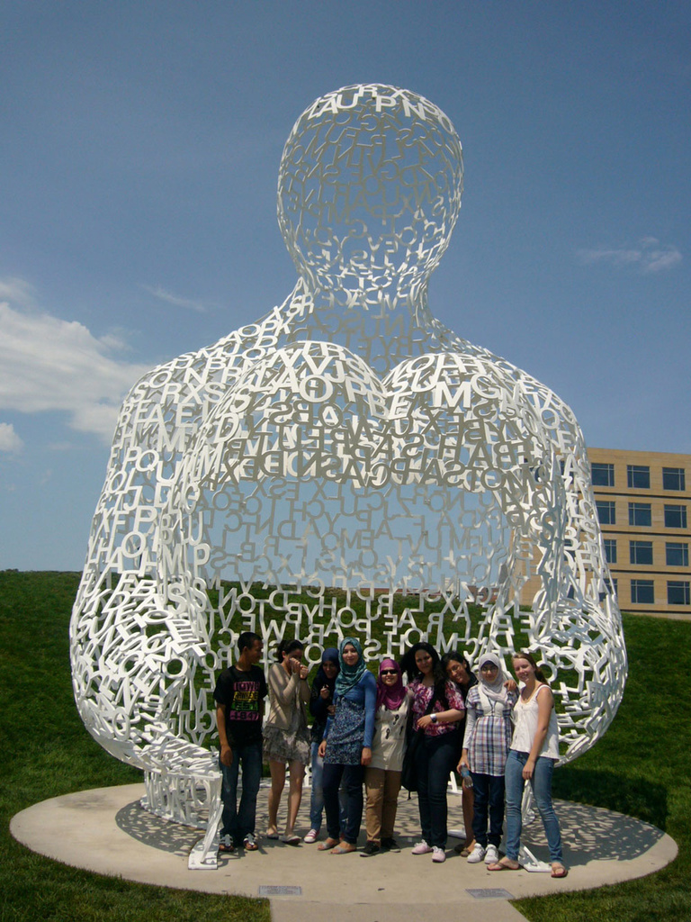 A group of Between the Lines participants pose with a sculpture at the Sculpture Garden in Des Moines, Iowa.