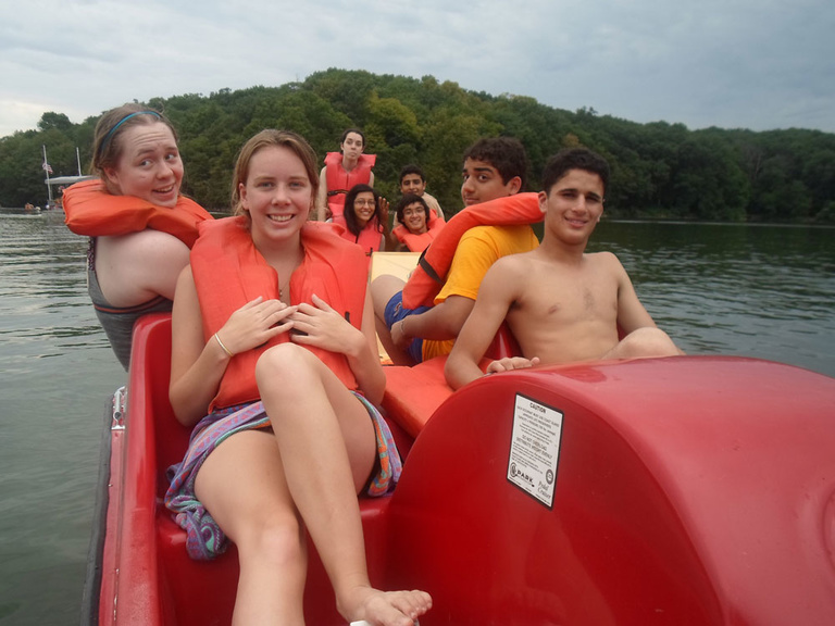 A group of Between the Lines participant pose for a photo while in a paddle boat.