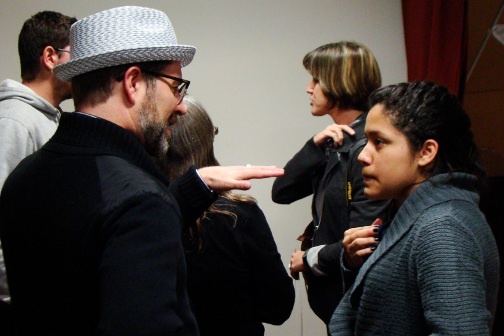 A group of people stand together having a discussion.