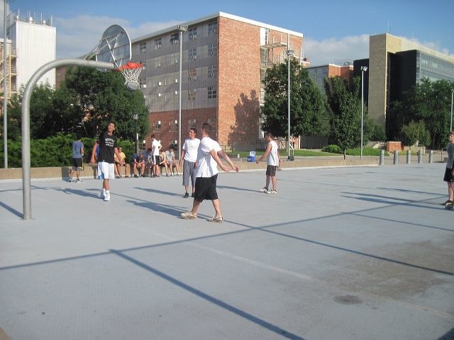 A group of Between the Lines participants play basketball outside of Burge Hall.