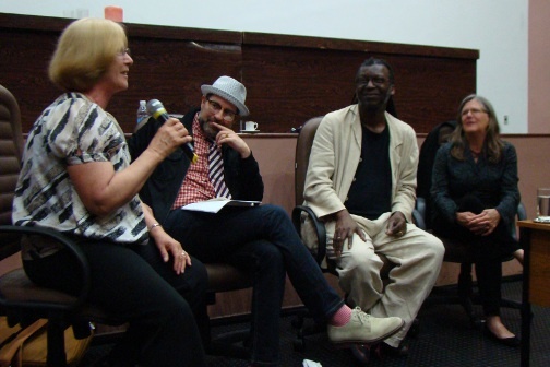 A group of people sit in a circle and have a discussion.