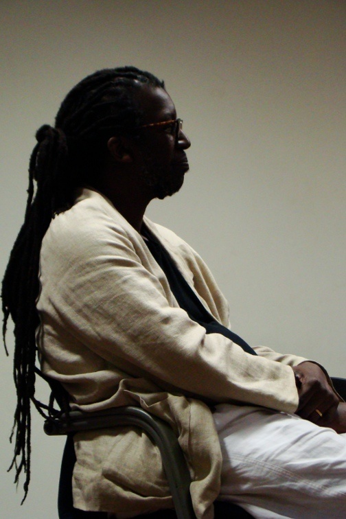 A photo of a man sitting in a chair.