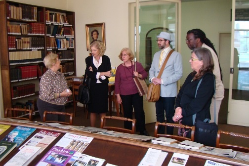 A group of Lines & Spaces participants listen to a woman speaking to them.