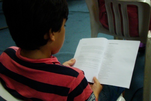 A child reads through a program.