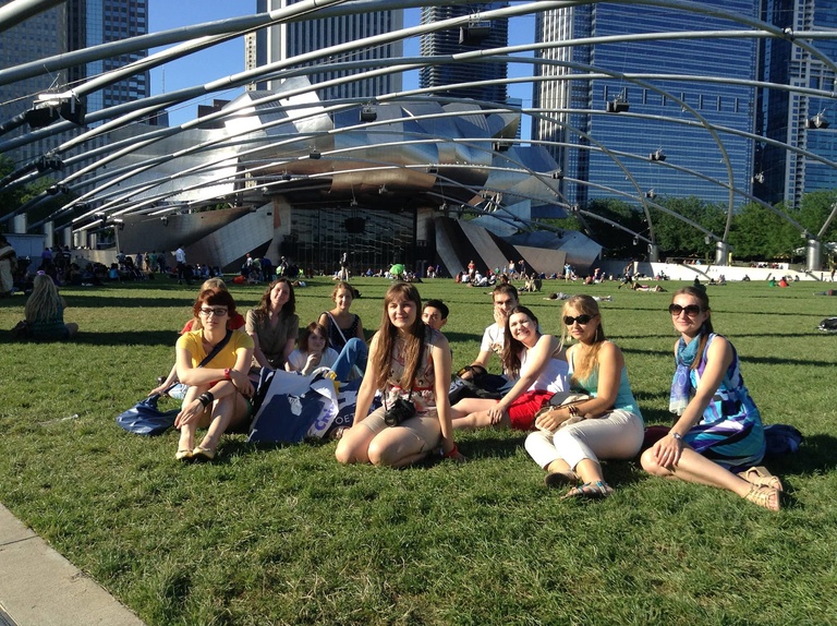 A group of Between the Lines pose for a photo in the grass at Millenium Park.