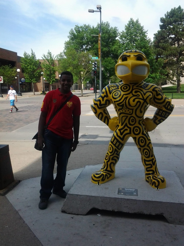 A Between the Lines partcipant poses with a statue of Herky the Hawkeye.