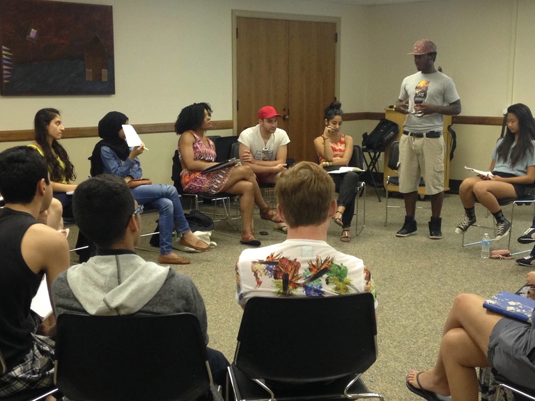 A group of Between the Lines participants sit in a circle while taking part in a poetry slam.