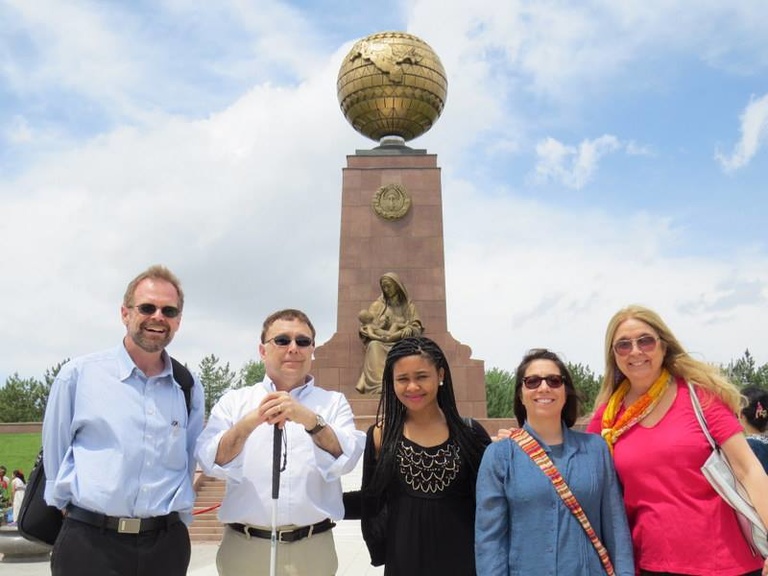 The IWP group pose in front of a golden statue.