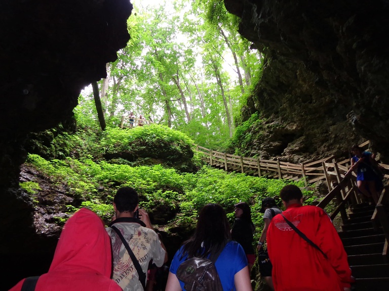 A group of Between the Lines participants hike a trail in the woods at Maquoketa Caves.