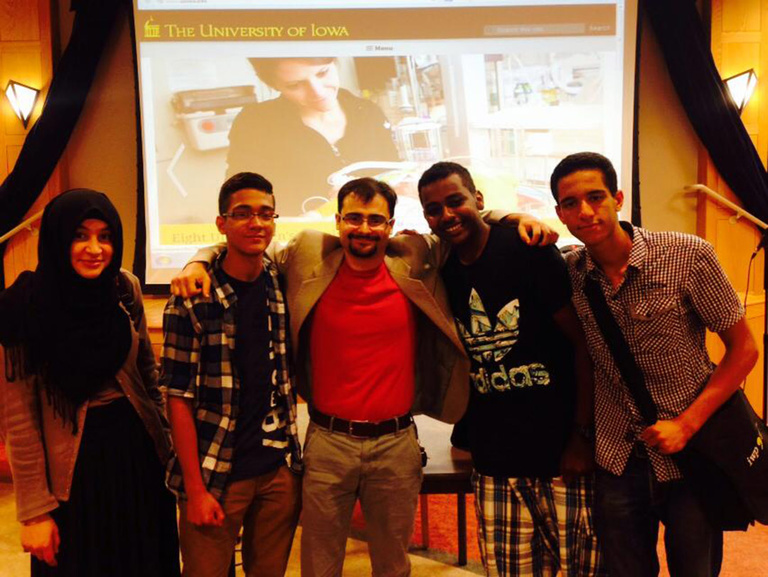 A group of Between the Lines participants pose for a picture with a guest speaker.