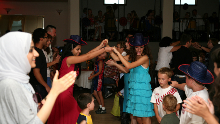 Between the Lines participant do an old-fashioned barn dance at a wedding reception in Walcott, Iowa.