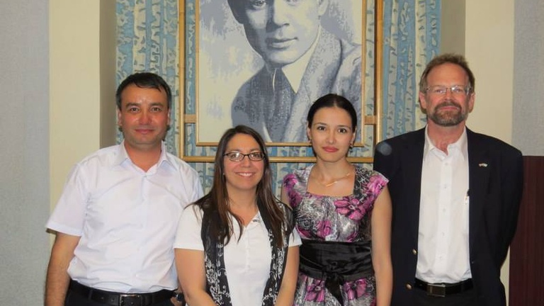IWP alum Aazam Abidov, IWP program officer Kelly Bedeian, IWP alum Alina Dadaeva & Chris Merrill pose for a photo.
