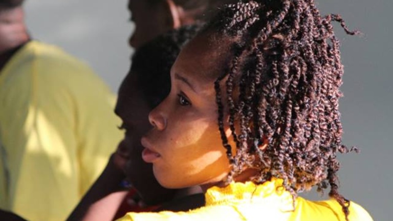 A photo of a woman wearing a yellow shirt who attended a Lines & Spaces workshop.