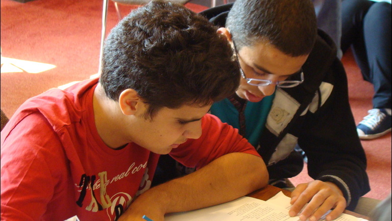 Two Between the Lines students study a piece of writing.