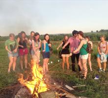 Participants having fun roasting marshmallows over a bonfire. 